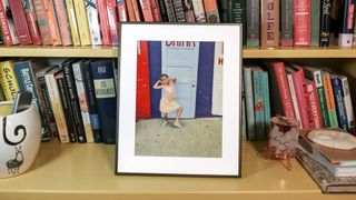 Aura Ink digital photo frame on a book shelf