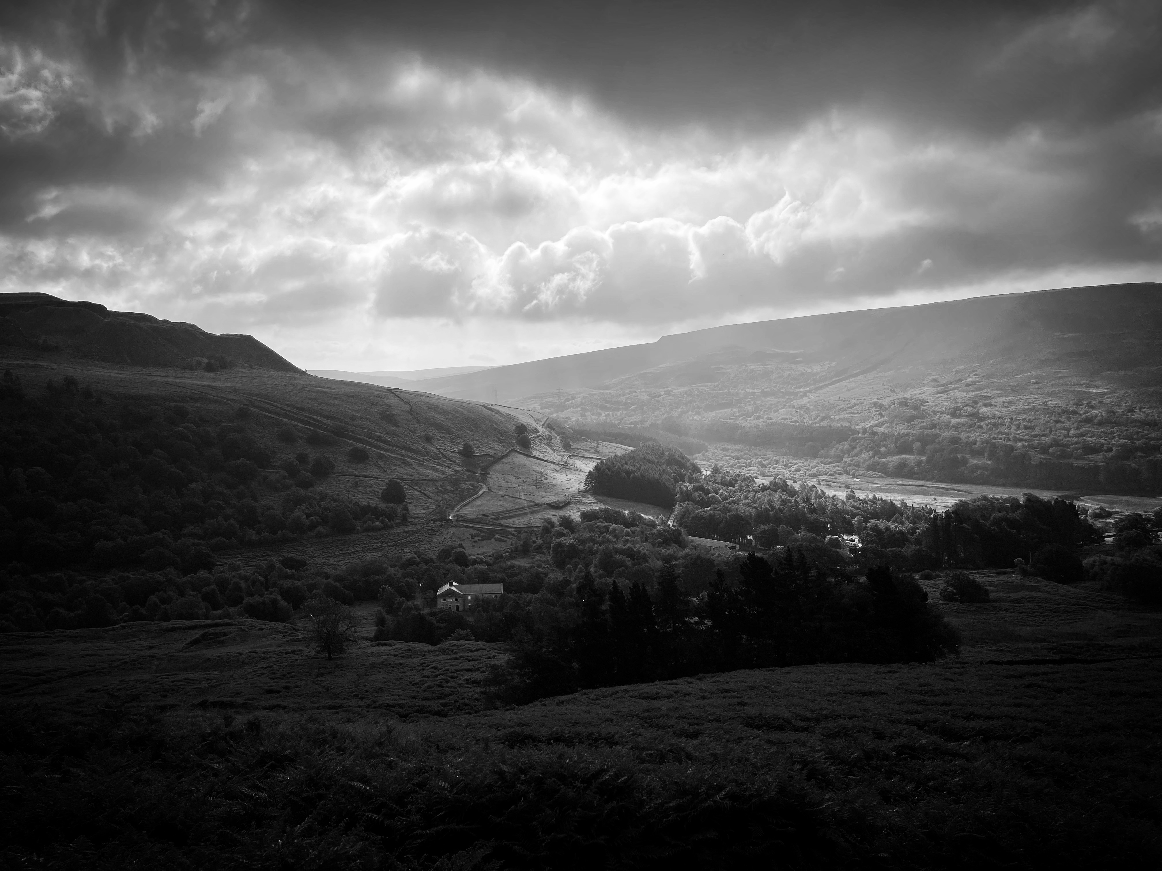 A monochrome photo of a hills and clouds