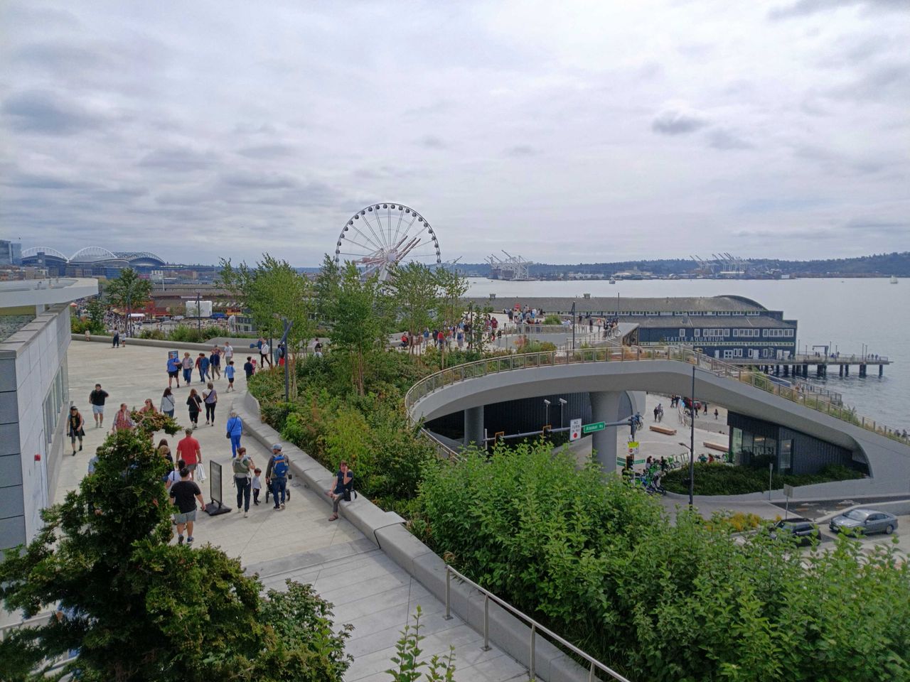 A waterfront walkway with people and trees