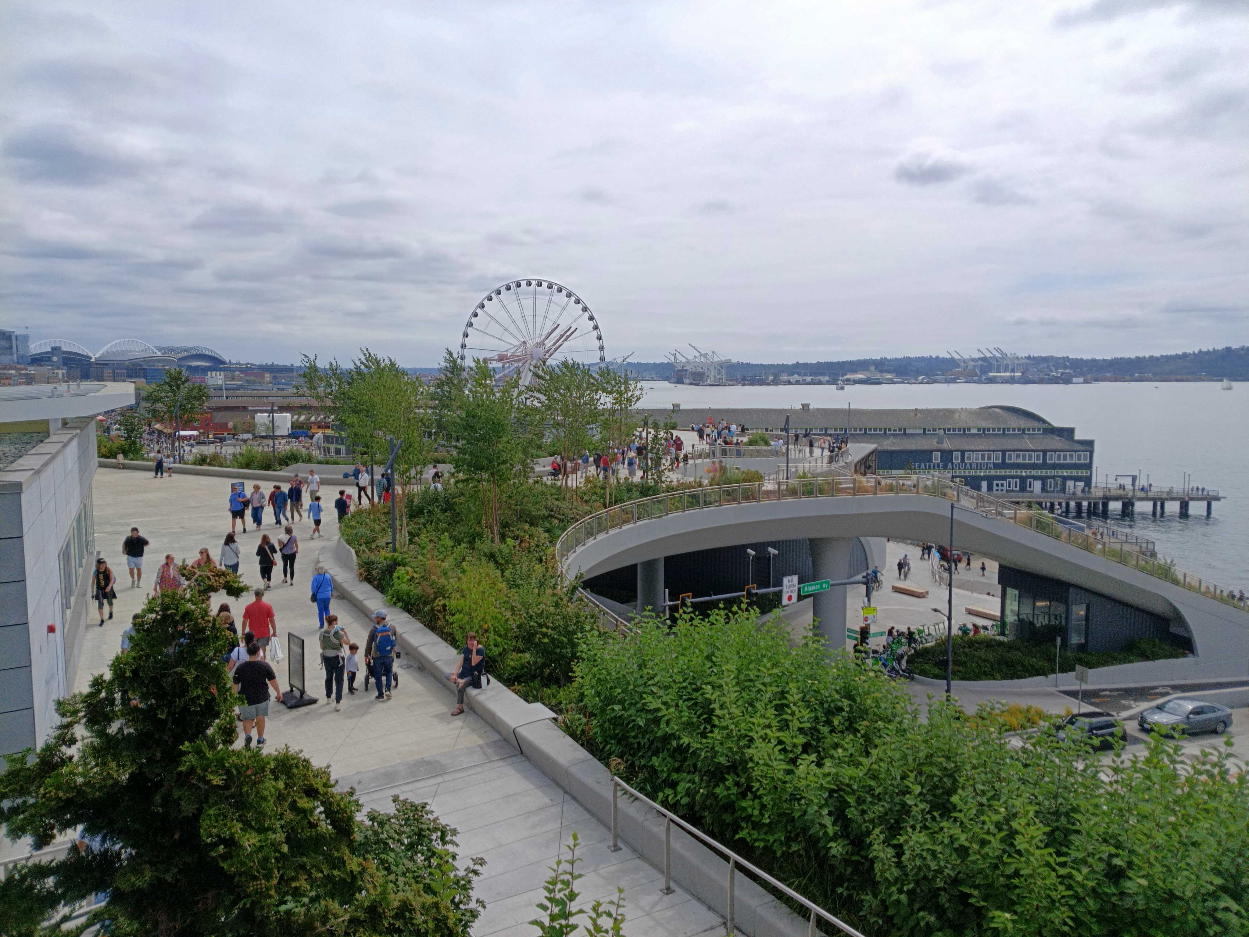 A waterfront walkway with people and trees