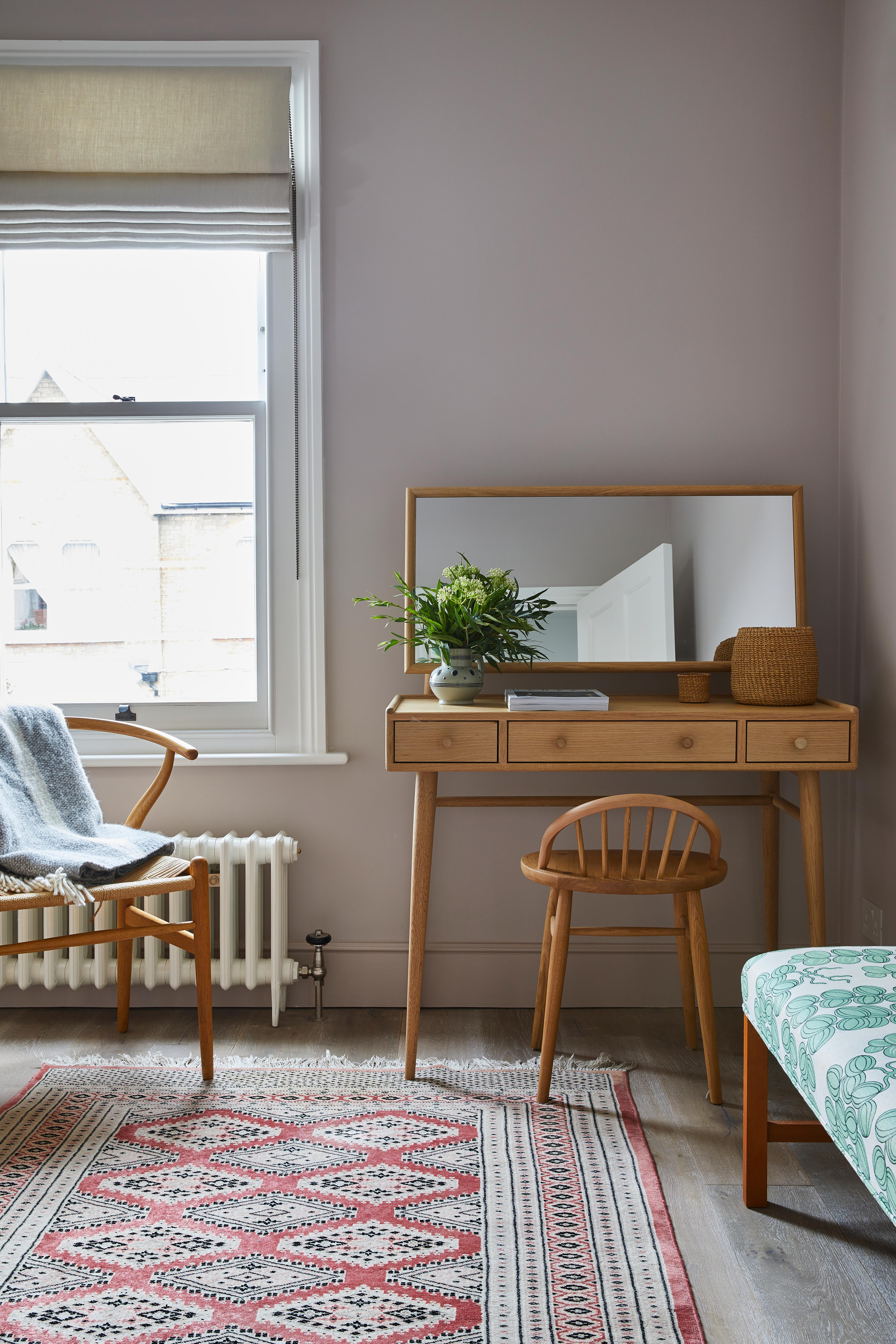 Blush pink bedroom with small wooden desk