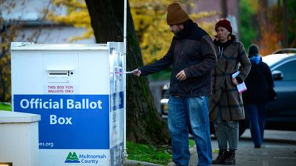 Voters in Portland, Oregon, drop ballots in ballot box