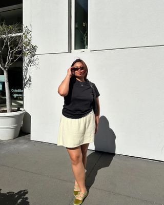 Influencer wears a white mini skirt.
