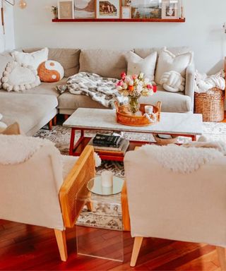 A small living room with two arm chairs, a coffee table, and an L-shaped couch