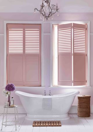 pink plantation shutters over a bath