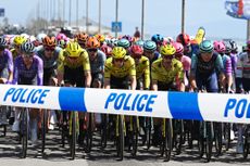 The peloton at the Giro d'Italia with police tape across it