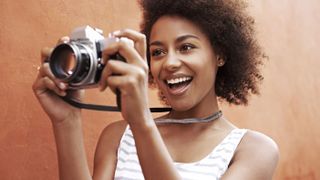 Best camera for photography - smiling woman holding a camera
