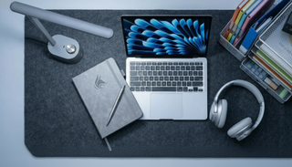 A selection of silver-themed home office accessories on a gray felt desk mat