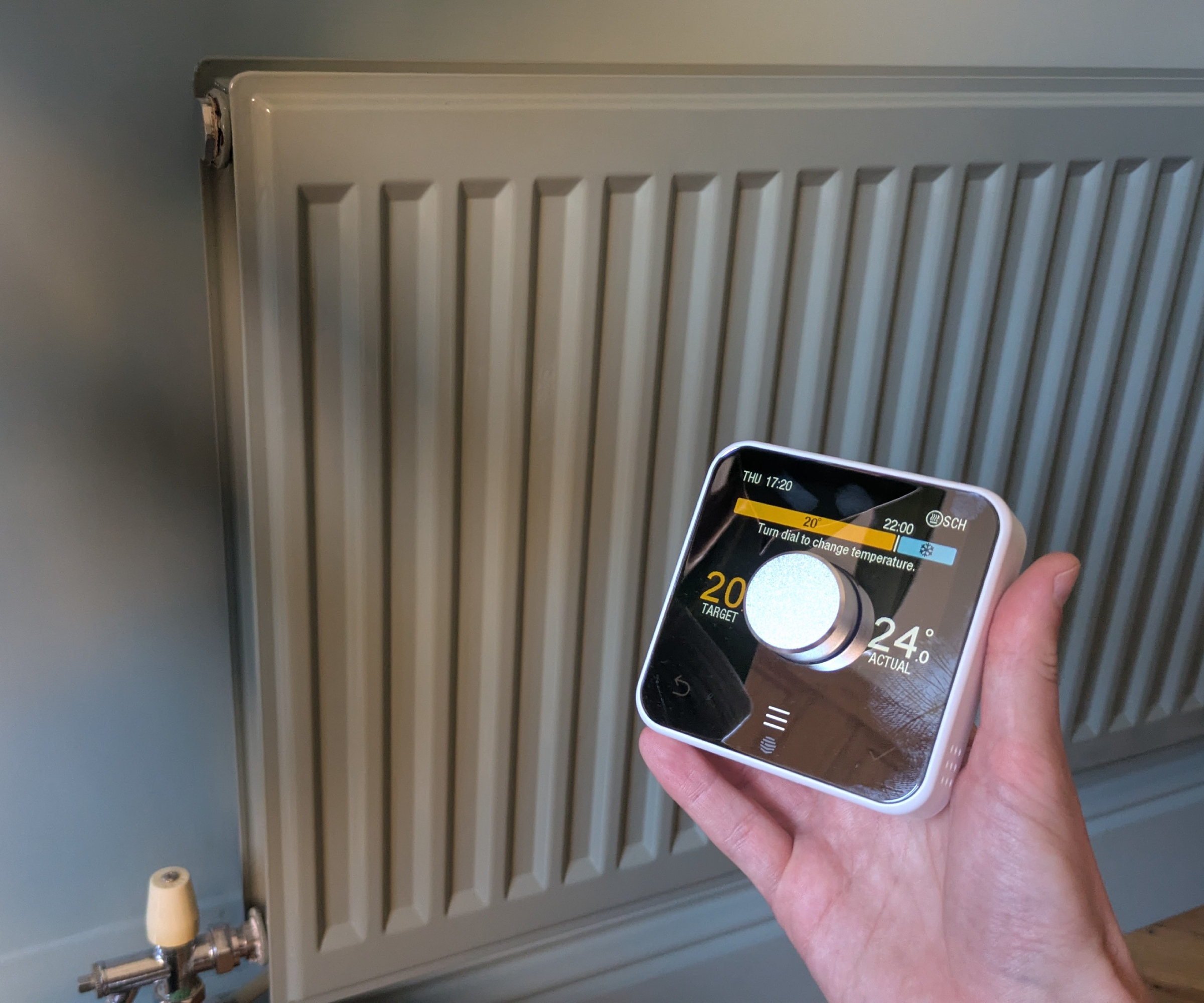 The Hive thermostat held up against a radiator