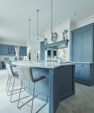A curved kitchen island in a blue farmhouse kitchen