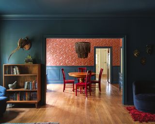 a teal colored living room with a red wallpaper and red furniture