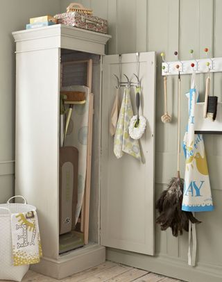 utility room with ironing boards in an armoire