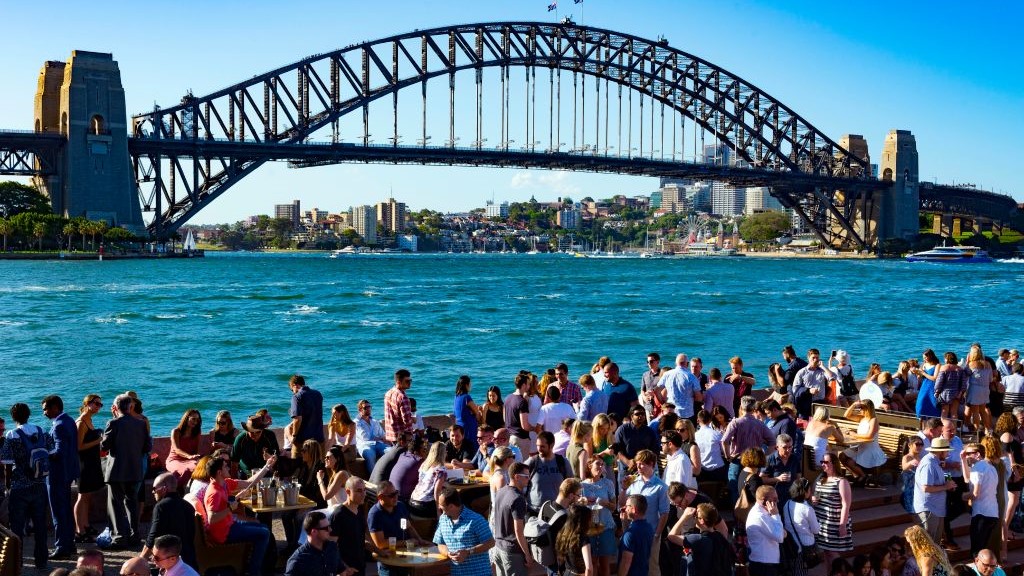オーストラリア、シドニーのシドニー・オペラハウスとハーバーブリッジ周辺のレストランやバーで飲んだり食べたりする人々。