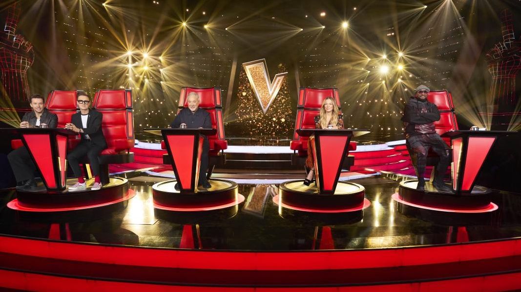 McFly duo Tom and Danny, Tom Jones, LeAnn Rimes, and will.i.am pose in their red chairs in The Voice UK 2024