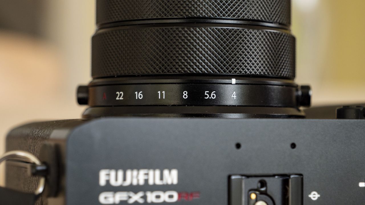 All-black Fujifilm GFX100RF rangefinder-style camera on a wooden table