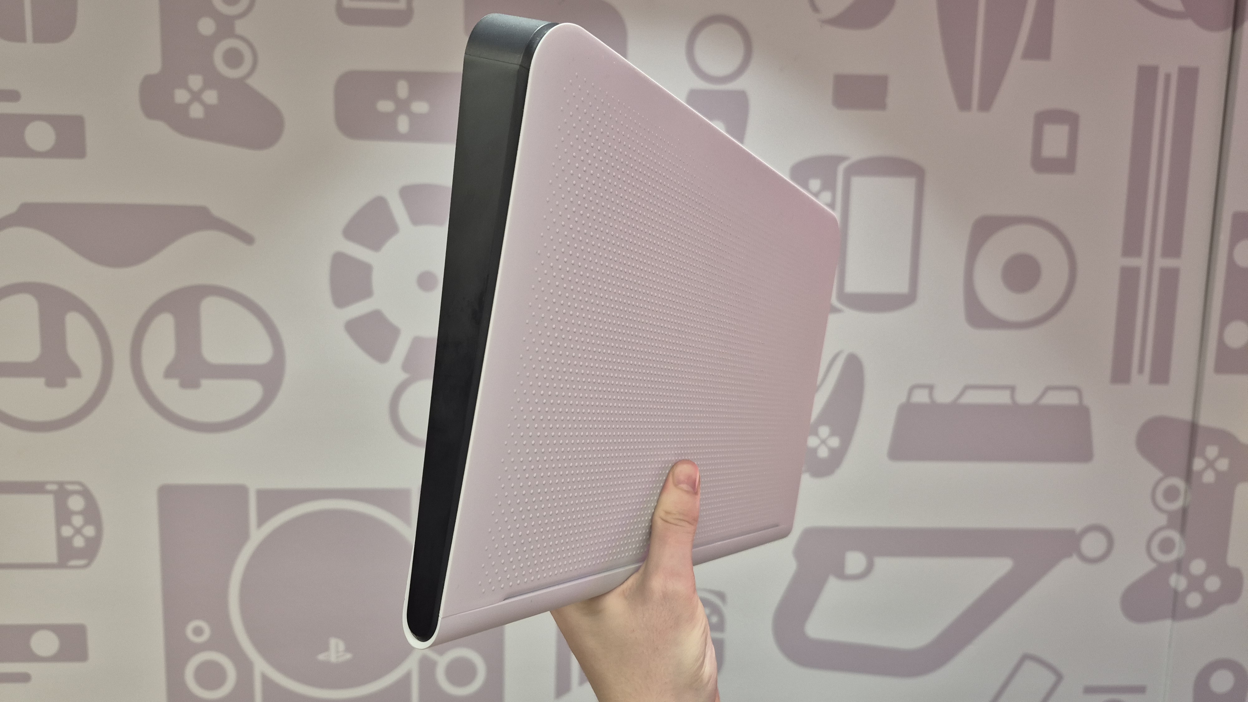 Man holding up FlexStrike Wireless Fight Stick against wall, showing textured underside