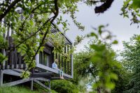 Biodiversity Net Gain could affect self builders such as this man with a laptop and headphones working outside in tree house