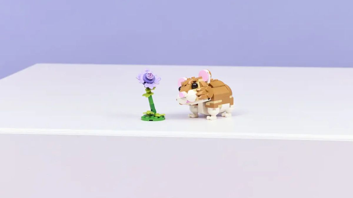 A Lego hamster and flower on a purple surface