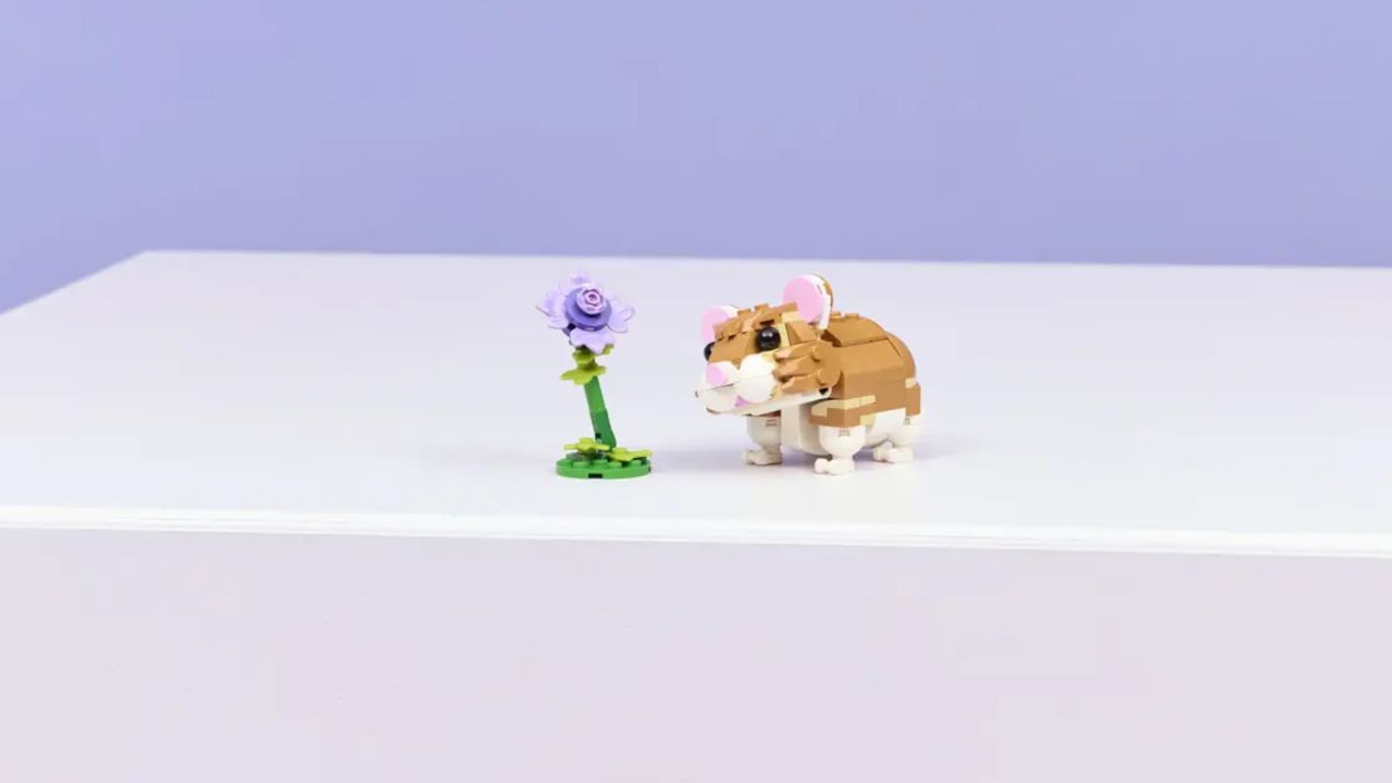A Lego hamster and flower on a purple surface
