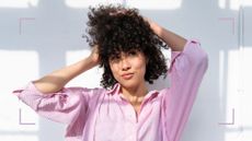 A woman touching her curly hair to demonstrate how often should you cut your hair