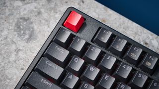 A black Lemokey X5 wired mechanical keyboard with red and black keycaps