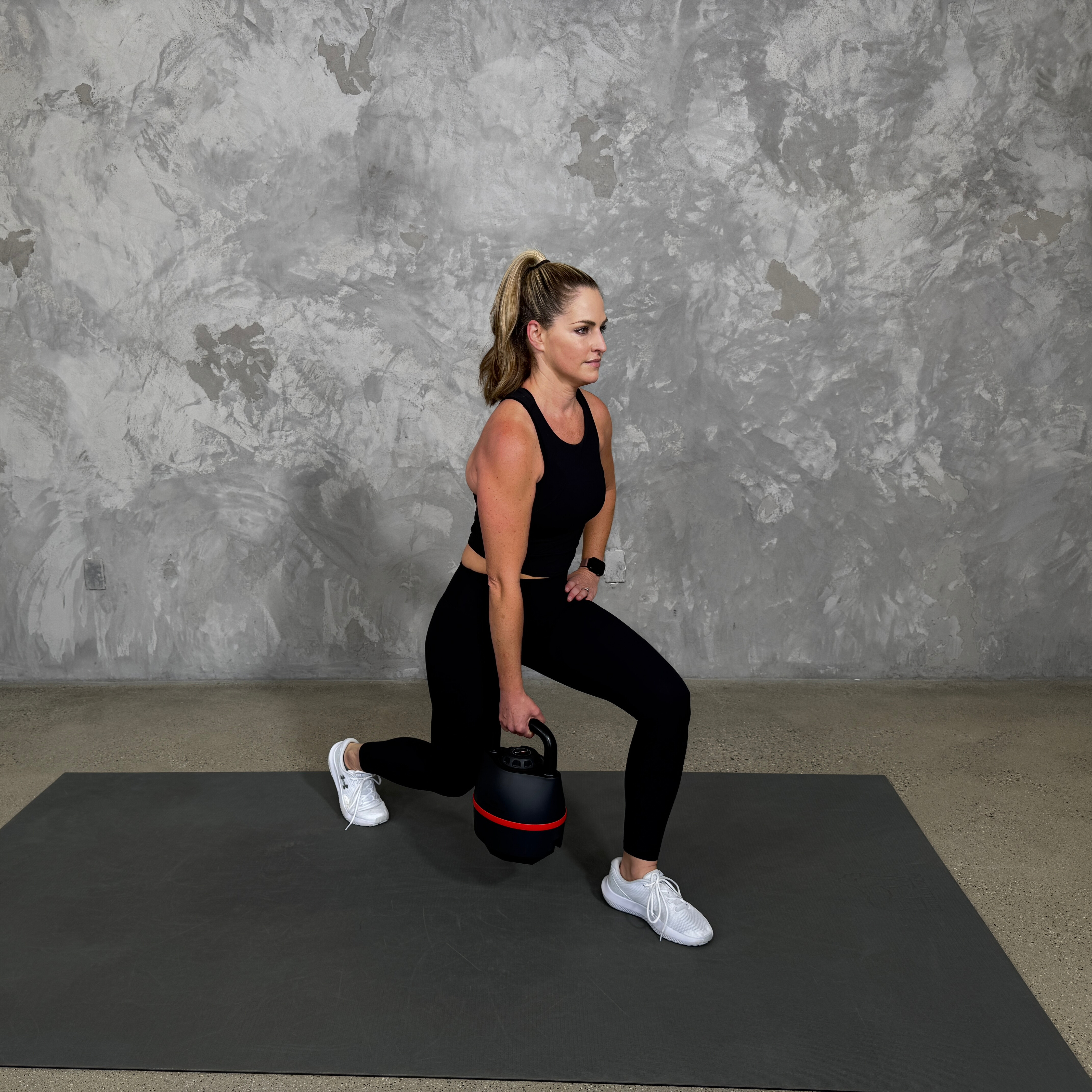 Woman in blue sportswear exercises with kettlebell