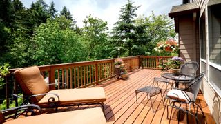 Wooden deck with furniture overlooking trees