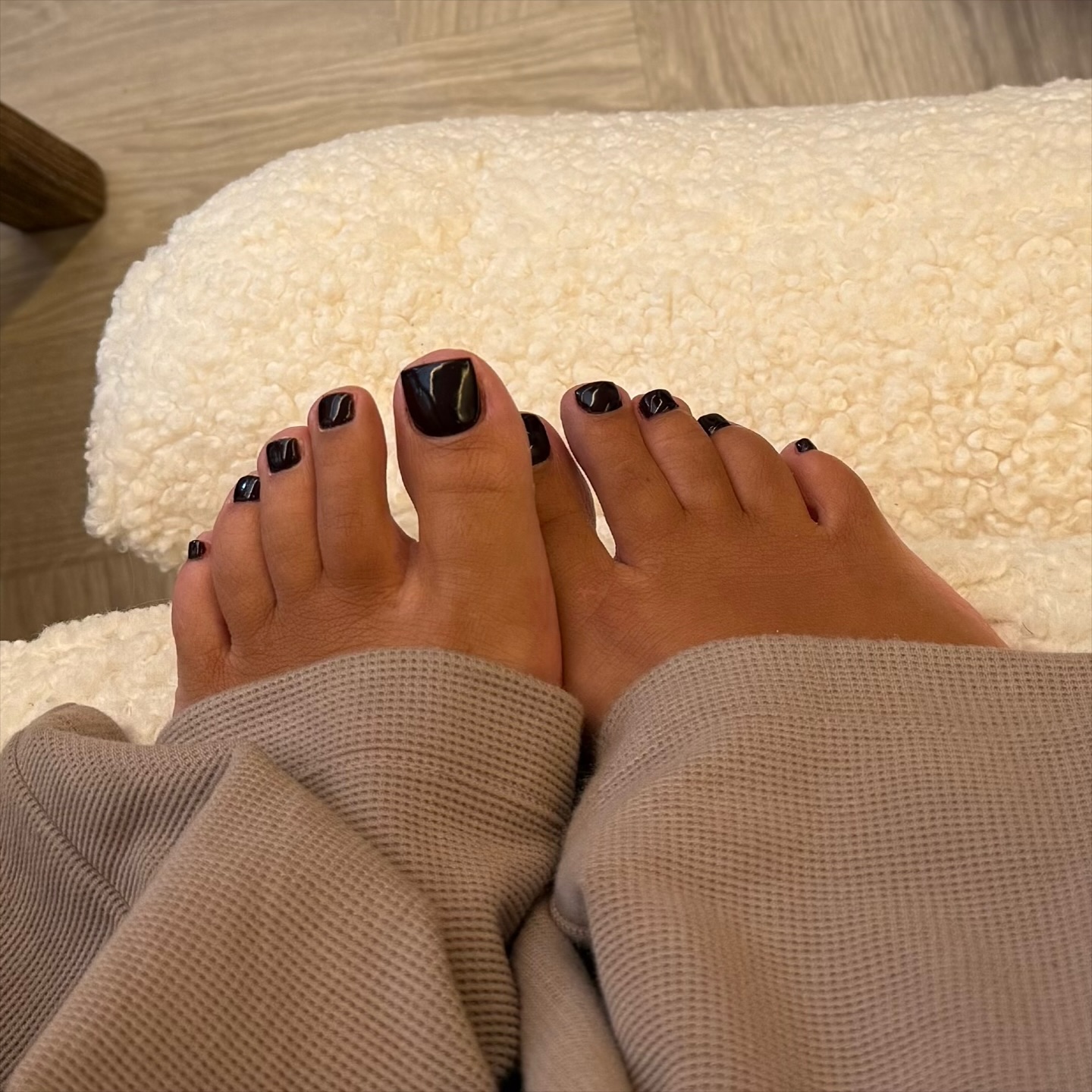 sweatpants and black toenails on a fuzzy white rug