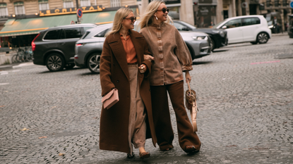 guests attend Paris fashion week spring summer 2025 in brown coats and jackets 