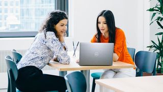 Two people working on a Dell laptop