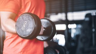 Close-up of man performing biceps curl with a dumbbell