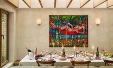 Table in extension dressed with candles for Christmas, with colorful art on the wall