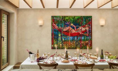 Table in extension dressed with candles for Christmas, with colorful art on the wall