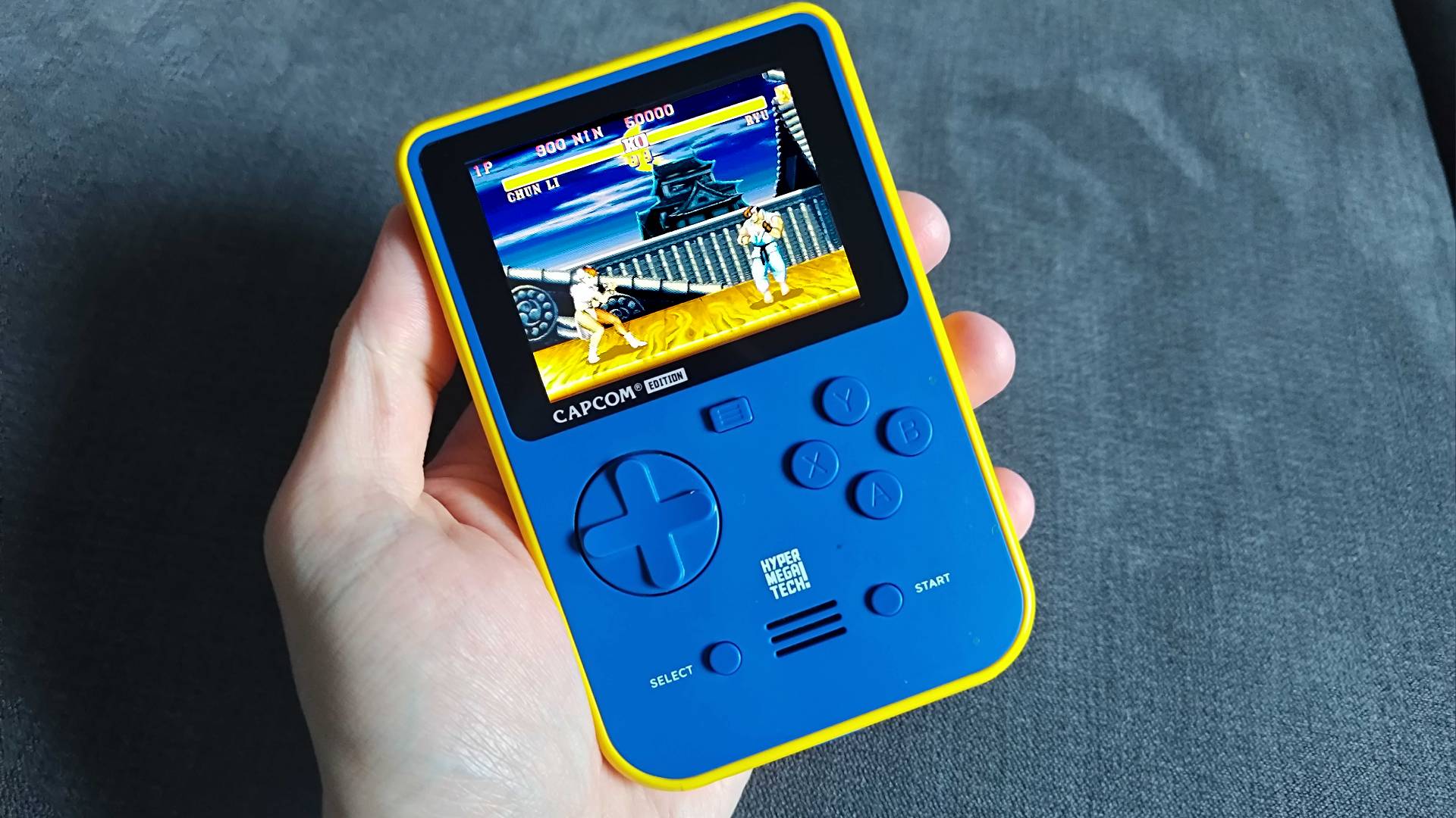 Hand holding Super Pocket Capcom Edition with Street Fighter 2 gameplay on screen.