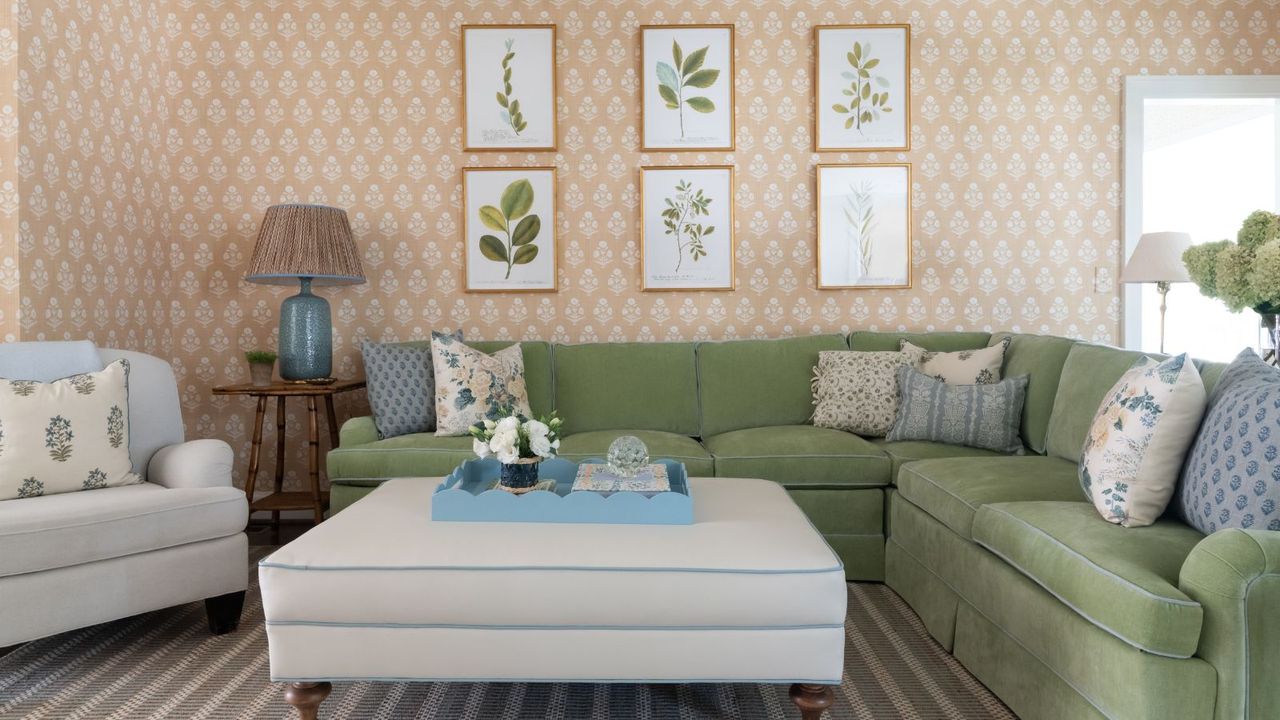 family living room with patterned wallcovering green sectional and white leather ottoman