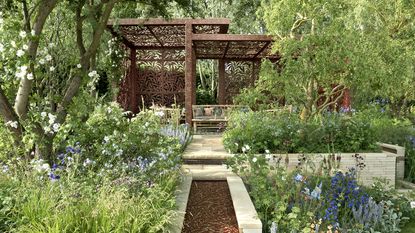 Chelsea 2022, Garden designed by Ruth Willmott, Garden Designer showing large flower beds and a pergola