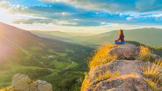Benefits of nature: woman meditating in sunshine