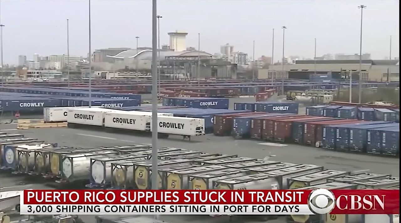 Containers of aid sit on the dock