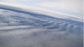 a view of clouds from above. Looking down on the clouds they appear to ripple through the sky.