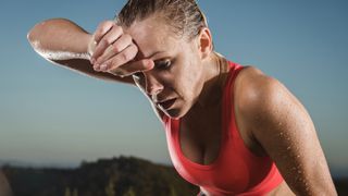 Woman wiping sweat from brow after workout