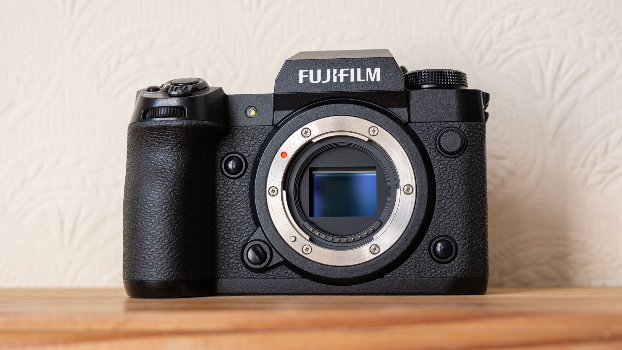 The Fujifilm X-H2 on a wooden shelf.