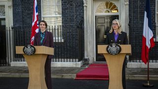 Abigail and Toussaint stand on podiums in Hostage