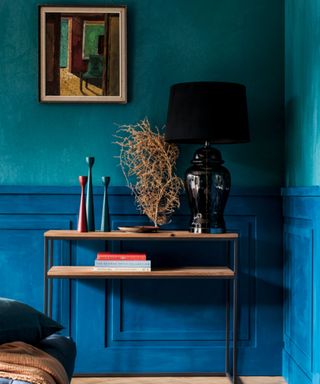 Teal painted walls with wooden console table