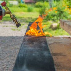 Burning raised bed lumber with a blowtorch