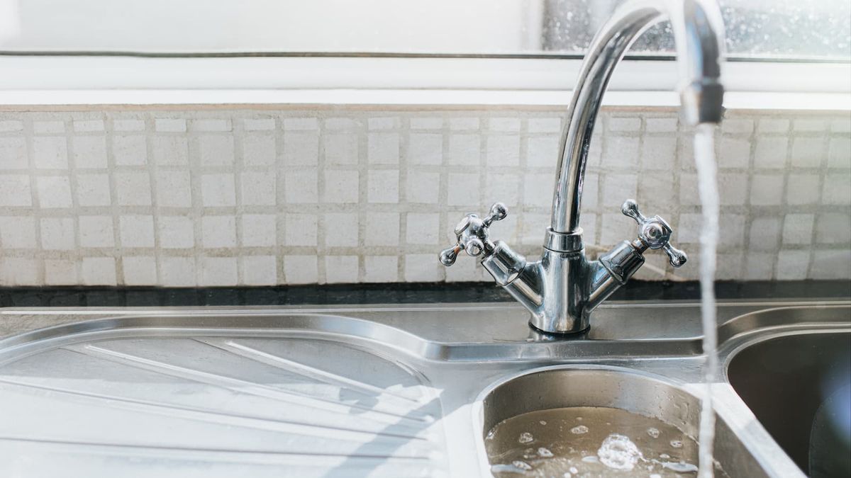 A chrome kitchen sink against a window