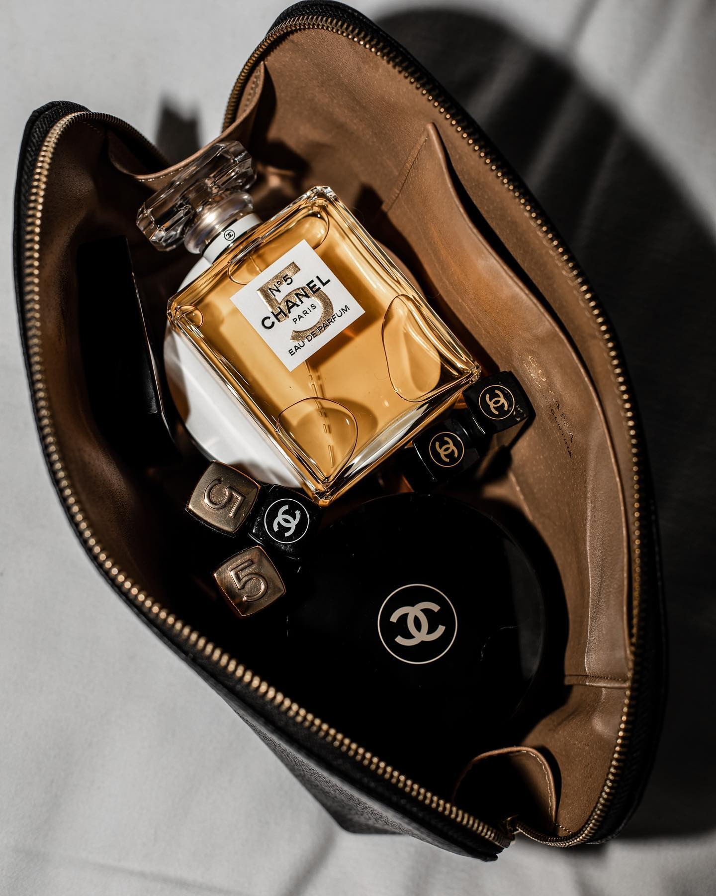 A picture of a makeup bag filled with Chanel products including Chanel No5