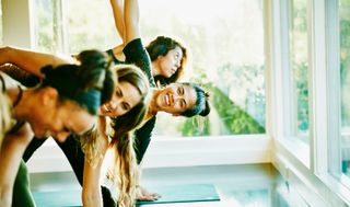 a group of women stretching in an exercise class setting