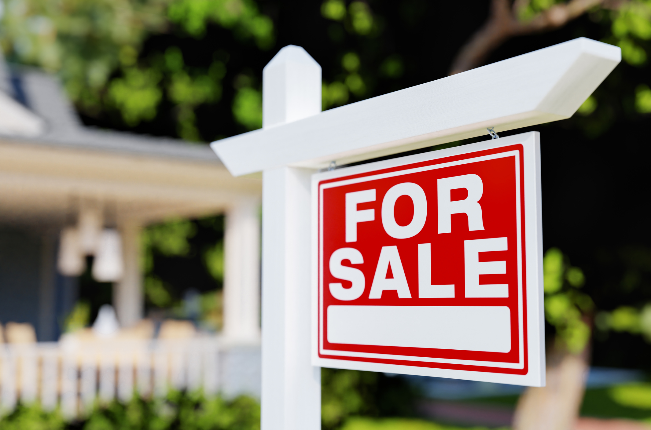 For Sale Real Estate sign in front of a house. 