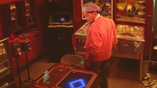 Giancarlo Esposito standing in the middle of a arcade in Maximum Overdrive.