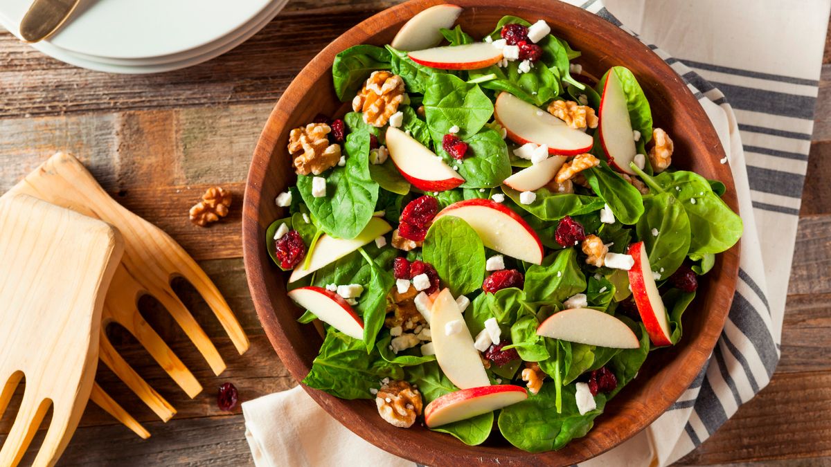 Apple and walnut salad in wooden bowl